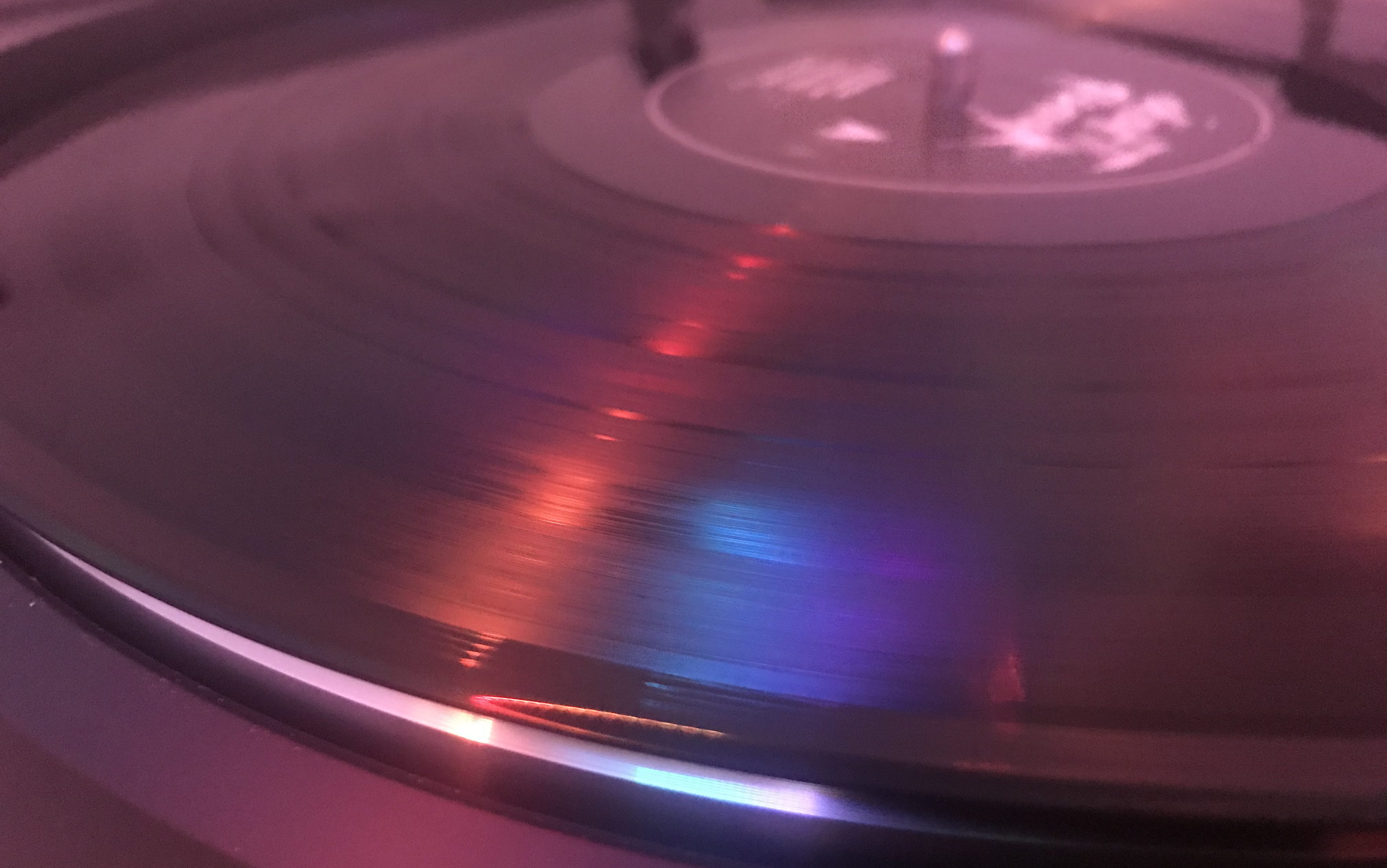 A spinning record of Daft Punk's Discovery with colored lighting reflected off it. 