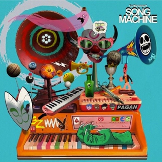 The album cover to Gorillaz's Song Machine. A color piano with various other objects placed on it, such as a melodica, horns, masks, a disembodied hand, and a model solar system.
