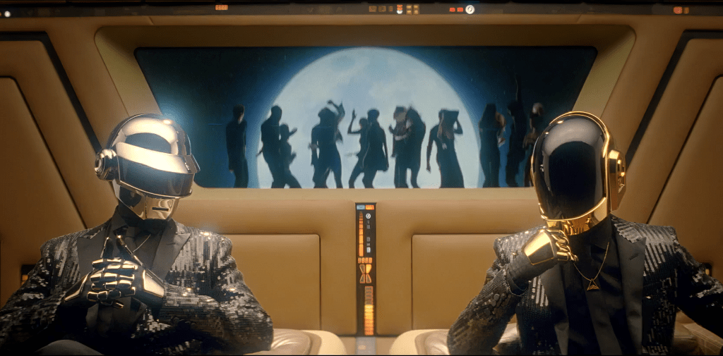 Daft Punk sitting in what looks like a spaceship with lights and tan walls. A window behind them looks out to a group of people dancing in front of a large moon.